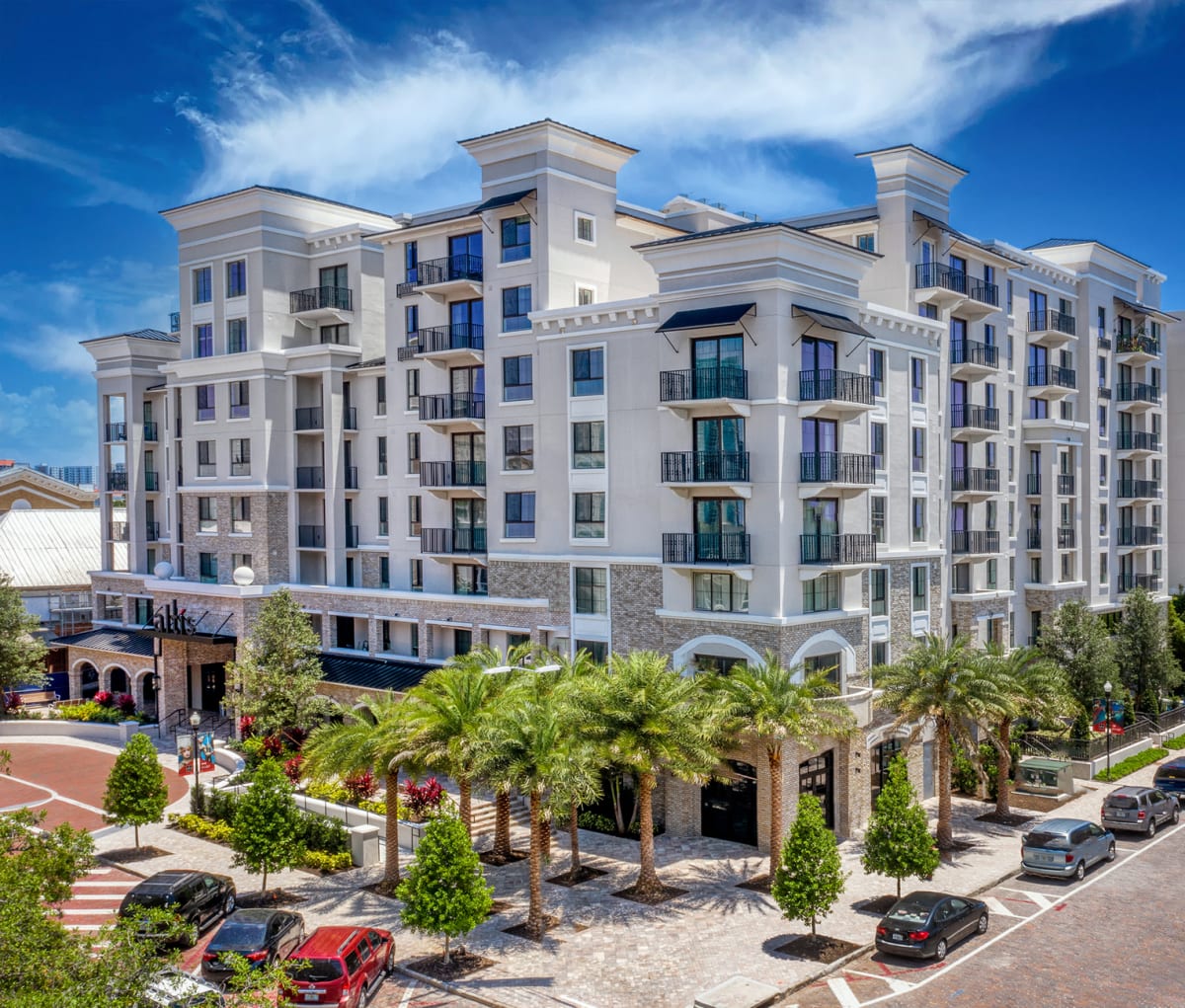 Mid-rise apartment building with balconies and palm-lined street in Tampa